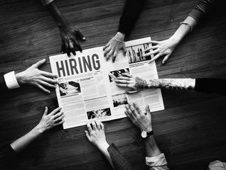 Diverse People Hands Reach Out for Hiring Newspaper Announcement