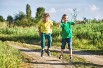 children play with a skipping rope on a summer evening