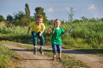 Fototapeta premium children play with a skipping rope on a summer evening
