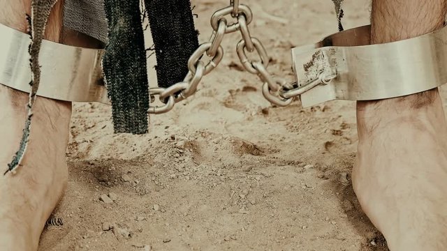 the legs of the prisoner in chains closeup