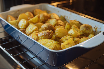 Closeup on baking potatoes with curcuma and other spices in roasting pan