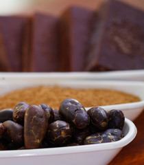 Close up of a dark dry cocoa bean inside of a white bowl