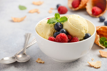 Vanilla ice cream with fresh berries on concrete background, selective focus