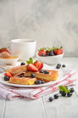 Waffles with fresh berries on rustic wooden background, selective focus