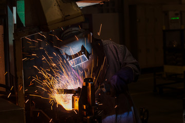  worker is welding in factory with protective  mask