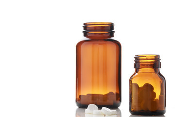 Pills bottles and white round pills on white background