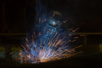 Industrial worker is welding in factory with protective  mask
