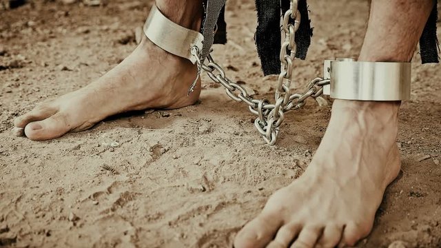 the legs of the prisoner in chains closeup