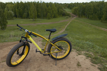 Fototapeta na wymiar Fat bike at summer countryside - dirty bicycle, horizontal