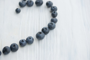 Blueberries in a white bowl on a wooden background