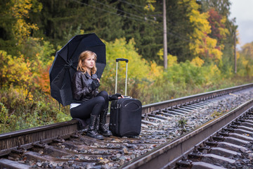 Girl, umbrella and rails in autumn day