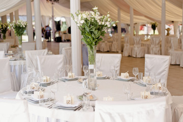 Wedding ceremony decoration in the restaurant. Decoration of wedding table with tender white textile