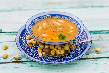 Vegetable soup with white asparagus and croutons on wooden background.