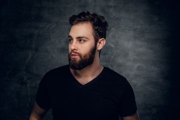 Naklejka premium Bearded male in a black t shirt over grey background.