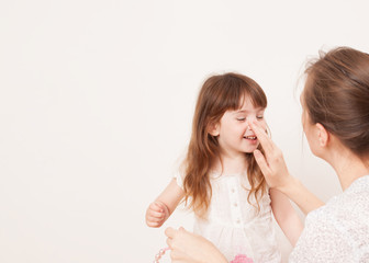 Mother playing with her daughter on white