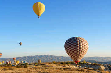 Fototapeta na wymiar Hot air balloons landing after flight in the morning. Cappadocia. Turkey