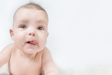 Cute baby showing tongue on a white background