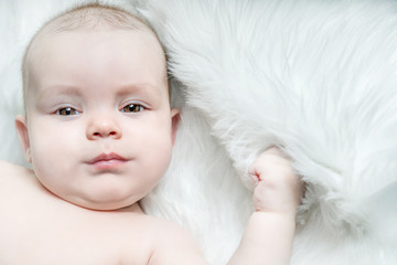 Cute baby lying on a white fur