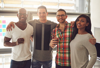 Cheerful office team standing with the beverages