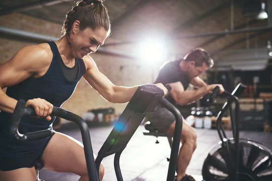 Man and woman hardly exercising at gym