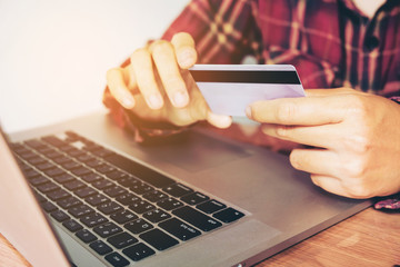 Man hand holding smartphone and credit card doing online banking.  shopping online