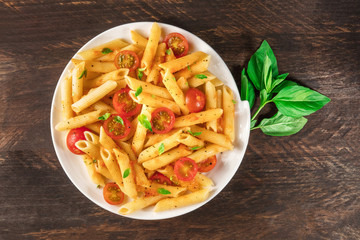 Penne pasta with tomato sauce and fresh basil leaves