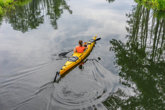 Girl kayaking on a river, beautiful nature landscape