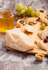 Honey, grape, different type of cheese and nuts on wooden background. Healthy food. Snacks and products