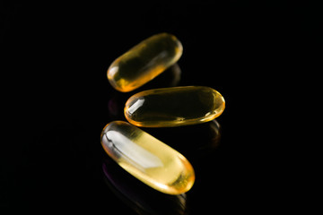 fish oil capsules on table black background