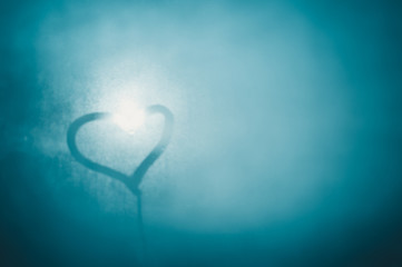 Closeup on love heart inscription over sweaty window glass background. Emotional solar creative concept symbol