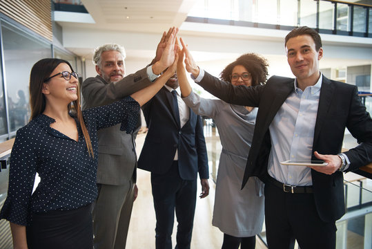 Business team giving high five in office