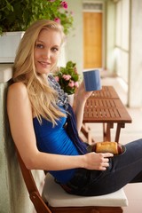 Young blonde woman drinking tea in the terrace