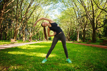 Young woman doing fitness exercises in park