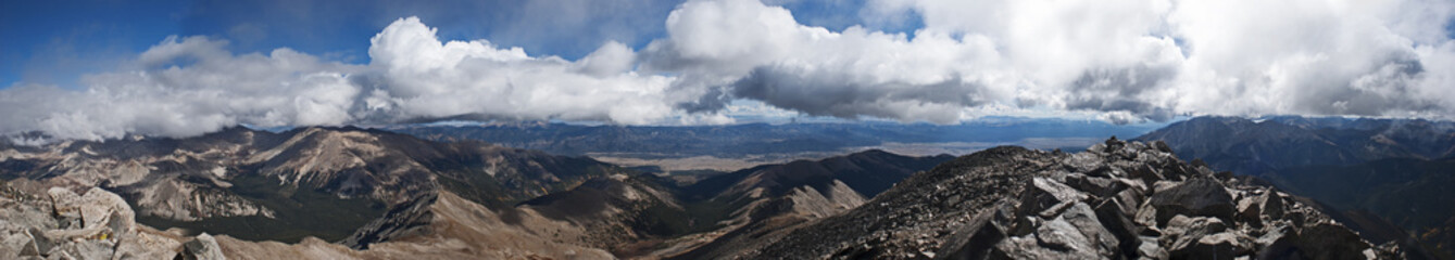 panorama of billowing clouds above rocks