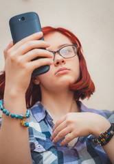 Fashion pretty young girl makes selfie portrait on smartphone.