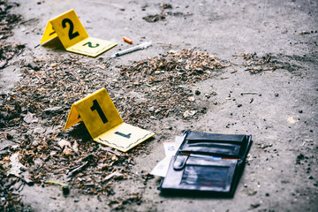 Crime investigation, yellow crime scene marker next to the wallet on the ground