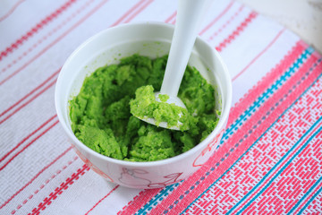 Broccoli puree in a white plate on a light background