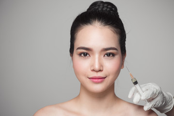 Beautiful asian woman gets beauty facial injections. Face aging injection.