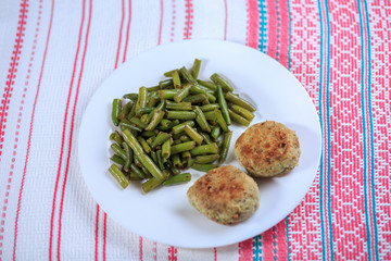 Cutlets with a stuffing with a garnish on a white plate on a light background