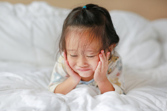 Cute little girl lying on bed at the morning.