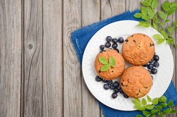 Homemade  blueberry muffins on rustic wooden background, top view, copy space