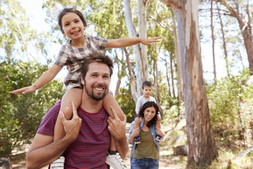 Children Riding On Parent's Shoulders On Countryside Walk