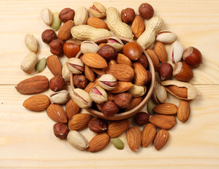 mix almonds, cashew nuts, hazelnut, peanuts, walnuts, pistachio in wood plate on wood background
