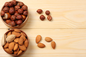 mix almonds, cashew nuts, hazelnut, peanuts, walnuts, pistachio in wood plate on wood background