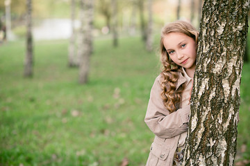 portrait of beautiful girl standing close to tree