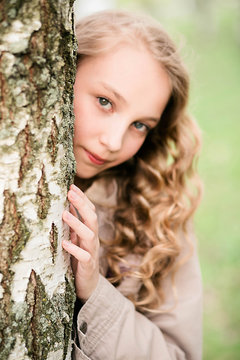 portrait of beautiful girl standing close to tree