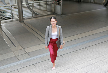 Fototapeta premium young business woman walking outside. Asian businesswoman office worker in downtown business district. 
