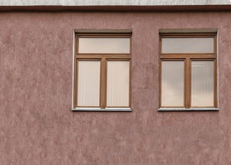 Two windows on a brown wall