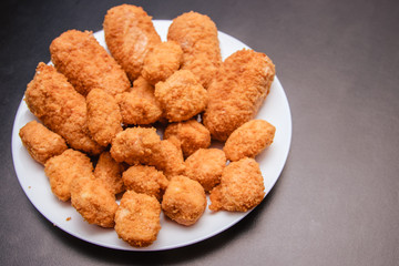 Cutlets in breading on a black background