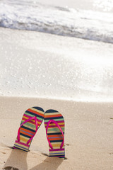 Colorful flip flops on the sandy beach. Vacation concept